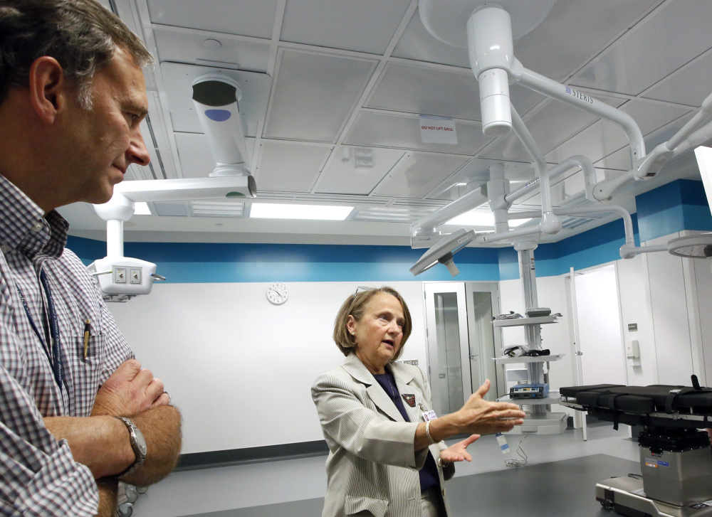 Dr. Brad Cushing, surgery department chairman, left, and Marty Riehle, vice president of patient care, show off one of Maine Med’ical Center's new operating rooms. Cushing says modern surgical facilities need more space for medical specialists and equipment.