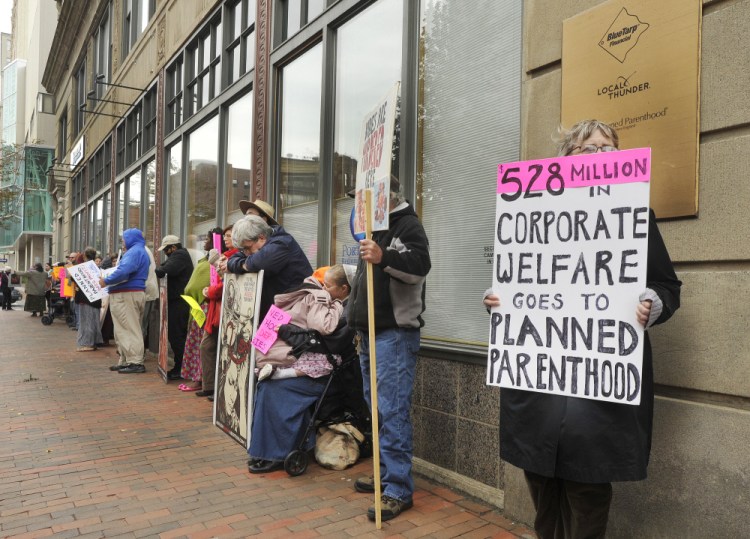 Anti-abortion activists hold a protest outside the doors of the Planned Parenthood office on Congress Street in Portland on Saturday Oct. 10.