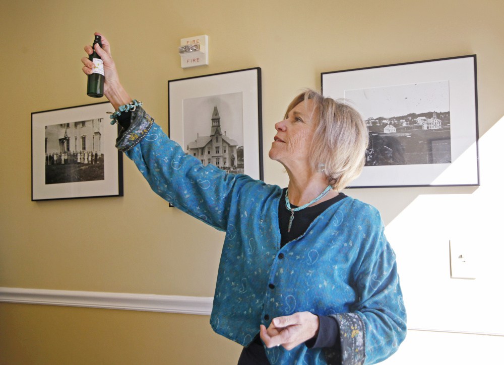 Ruth Kirkwood of Portland sprays sage mist to clear out negative energy Sunday in Freeport. "It's a smoke-free alternative to smudging," she said.
 Jill Brady/Staff Photographer
