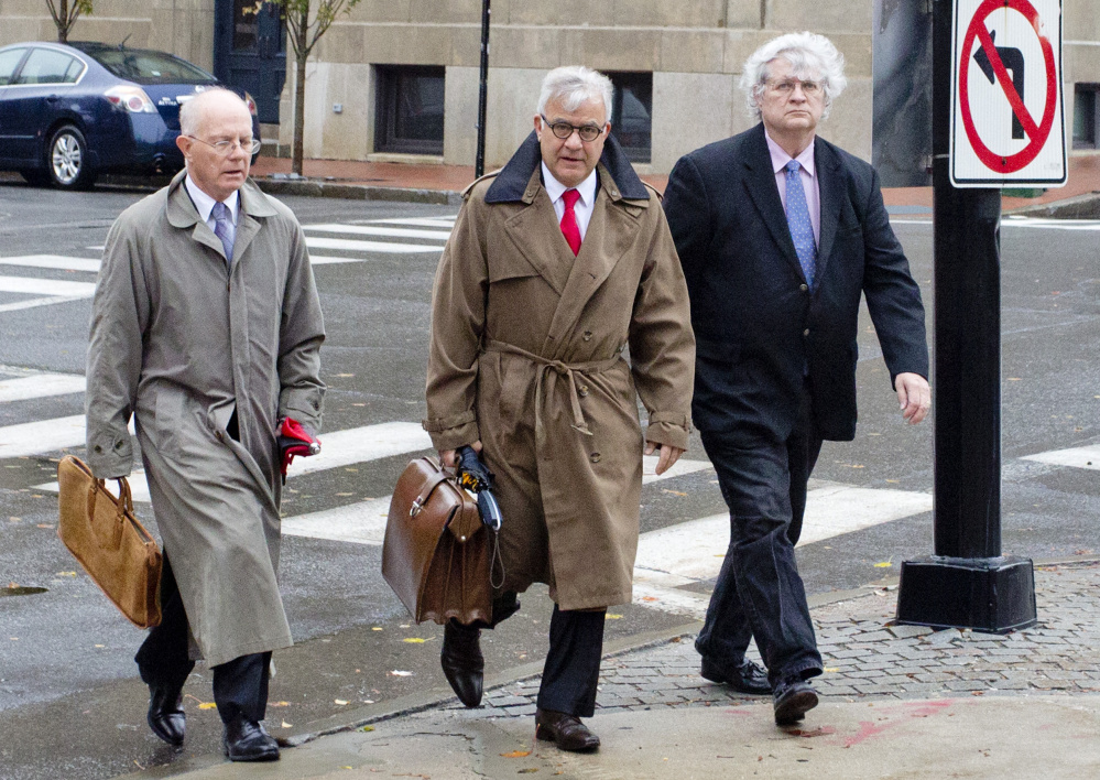 Dr. Joel Sabean of Falmouth, right, walks into U.S. District Court in Portland on Thursday to face a 58-count indictment. With him are attorneys Jay McCloskey and Thimi Mina.
