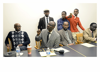 Claude Rwaganje, center, speaks during a meeting of immigrant Mainers announcing the start of a new political action committee at the Lewiston Public Library on Oct. 9. (Press Herald photo)