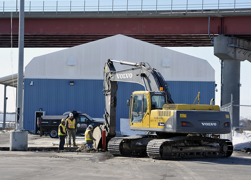 Workers at the International Marine Terminal prepare an area where smaller businesses will pool their products on pallets before they are transferred to a container for shipment.