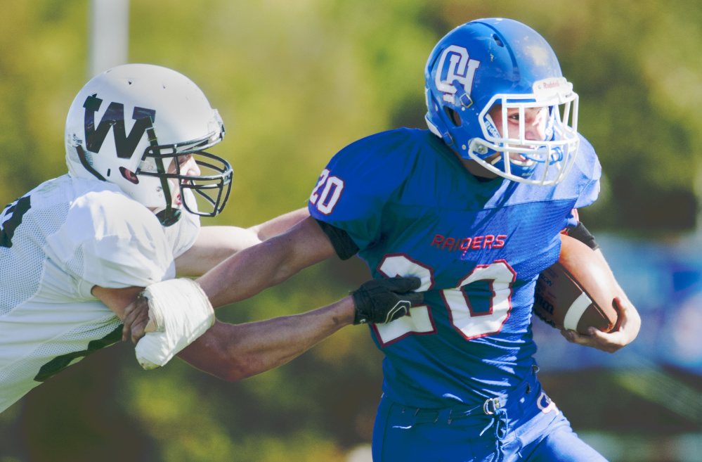 Winthrop/Monmouth’s Ben Ames, left, tries to tackle Oak Hill running back Levi Buteau during a game earlier this season in Wales. The teams meet again Saturday in the Campbell Conference Class D South semifinals.