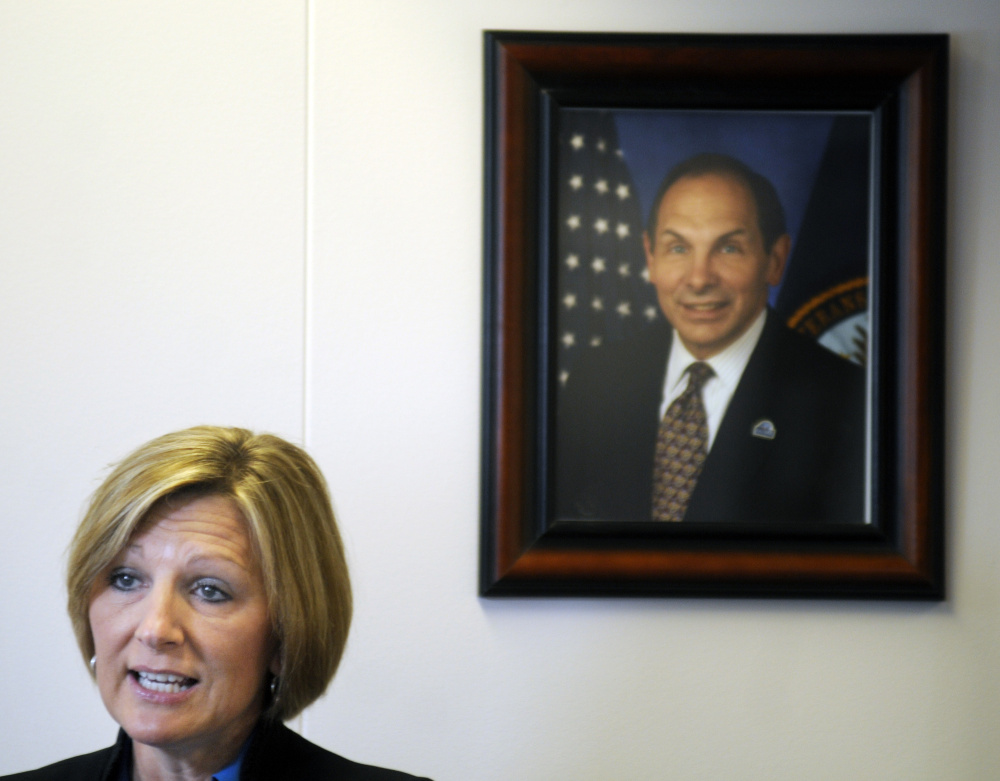 Julie Carie, acting director of the Togus Regional Office of the Veterans Benefits Administration, discusses the reduction in waiting times for claims on Tuesday beneath a portrait of Veterans Administration Secretary Robert MacDonald.