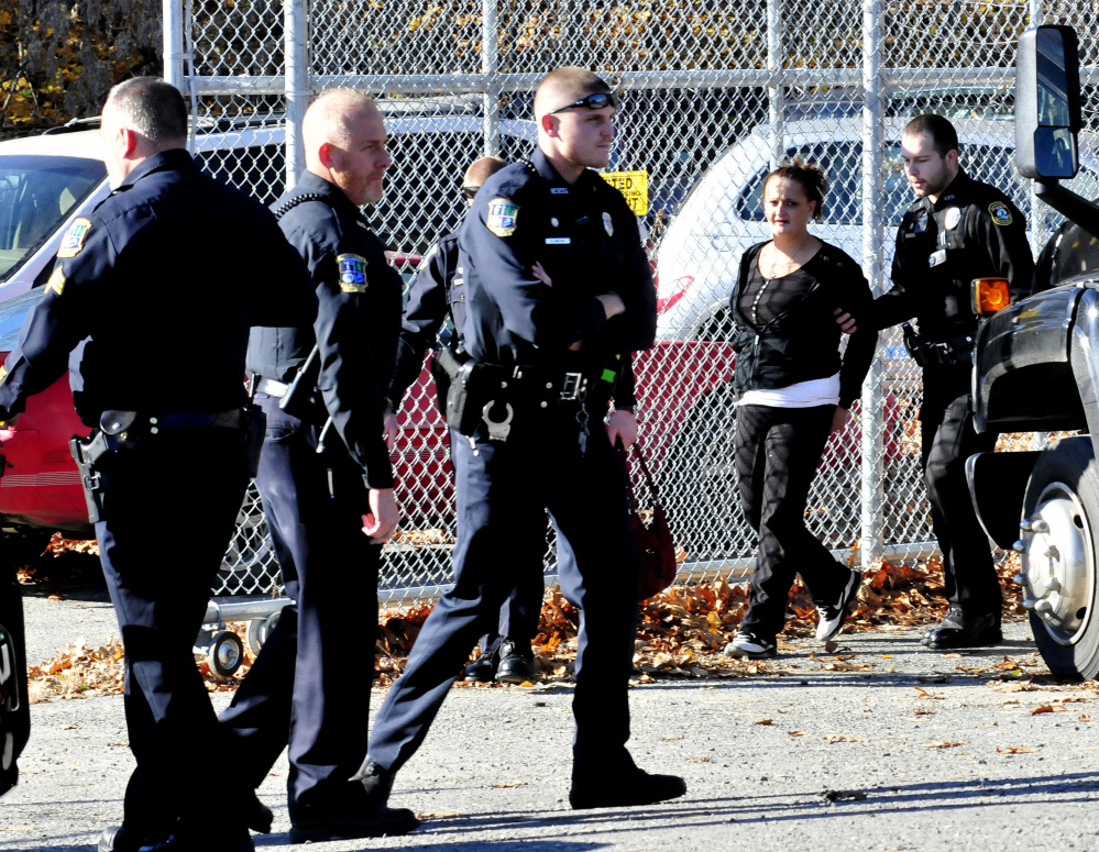 Police officers from Waterville, Winslow and Fairfield are on the scene as Melinda Caven is found hiding behind the Ace Tire store on Drummund Avenue in Waterville on Tuesday. Caven allegedly caused a three-car crash in Fairfield and also hit a house in that town before she was caught up to in Waterville.