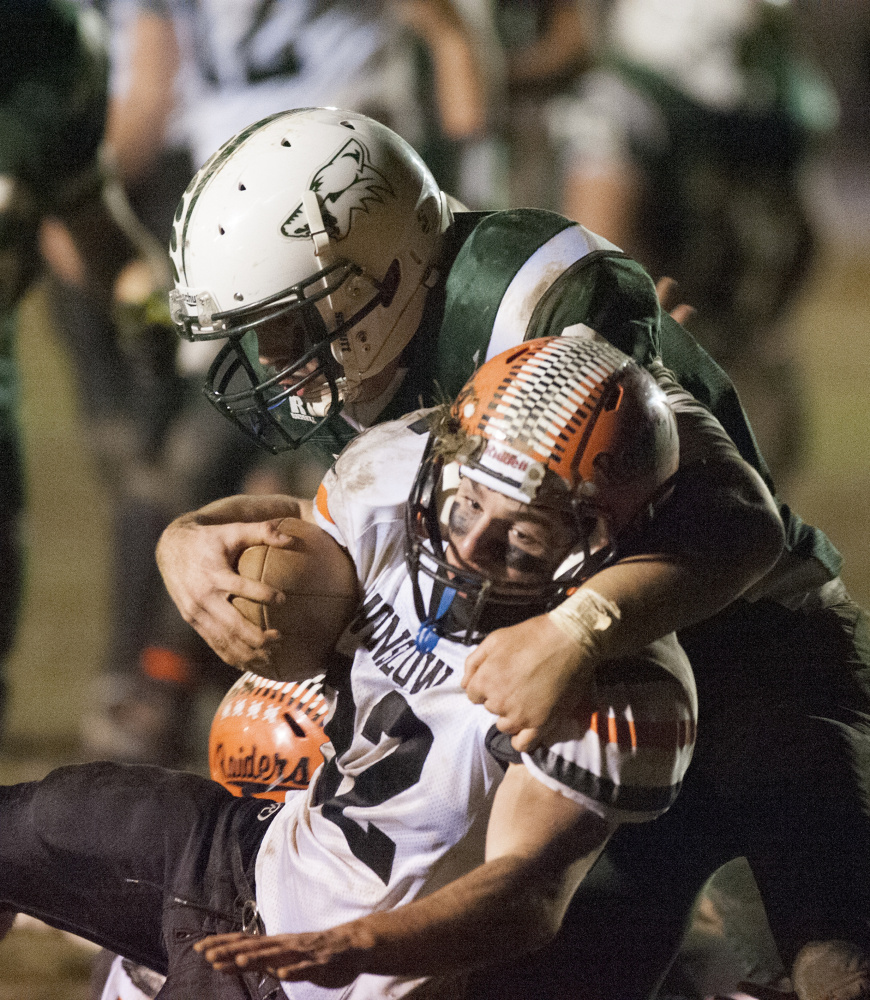 Winslow running back Nate St. Amand is tackled by Old Town’s Andre Miller during the Class C North championship game last Friday night in Old Town.