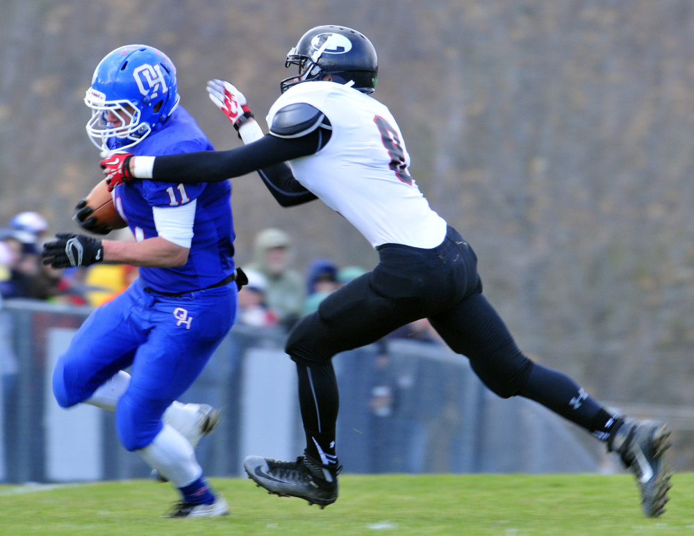 Oak Hill receiver Jonah Martin, left, gets tackled by Lisbon’s Caleb Little during the Campbell Conference Class D title game against Lisbon on Saturday in Wales.