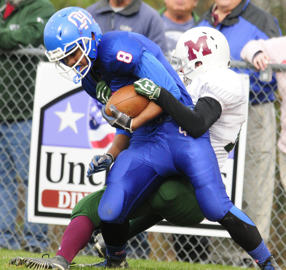 Oak Hill receiver Darryn Bailey, left, is wrestled down by Winthrop/Monmouth’s Andrew Pazdziorko during a Campbell Conference Class D semifinal game two weeks ago in Wales. Bailey, along with his fellow receivers, has turned in a strong season for the Raiders.
