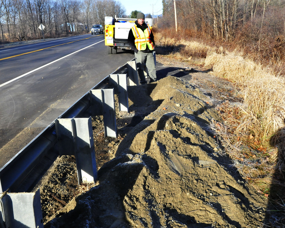 Jeremy Greenman, an oil and hazardous materials responder with the Department of Environmental Protection, surveys the scene along U.S. Route 2 in Farmington on Wednesday where an oil tank truck overturned, spilling some fuel, after a minivan crashed into it Tuesday night.