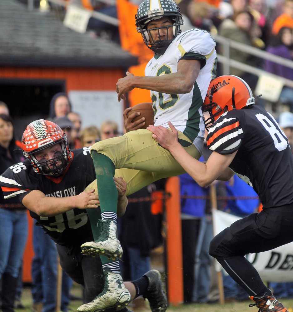 Winslow linebacker Kenny Rickard, left, and teammate Hunter Campbell (84) tackle Mt. Desert Island High School’s Spencer Kashmir during a Big Ten Conference semifinal game Saturday in Winslow.