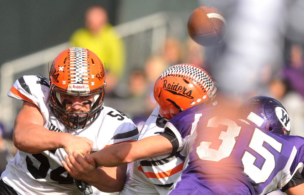 Winslow linebackers Alec Clark (54) and Patrick Hopkins, center, break up a pass intended for Waterville’s Devon Begin during a Big Ten Conference game earlier this season at Drummond Field in Waterville.