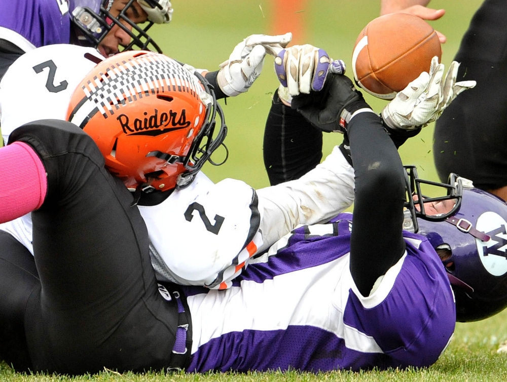Winslow linebacker Patrick Hopkins goes for the ball with Waterville’s John Evans during a Big Ten Conference game this season at Drummond Field in Waterville.