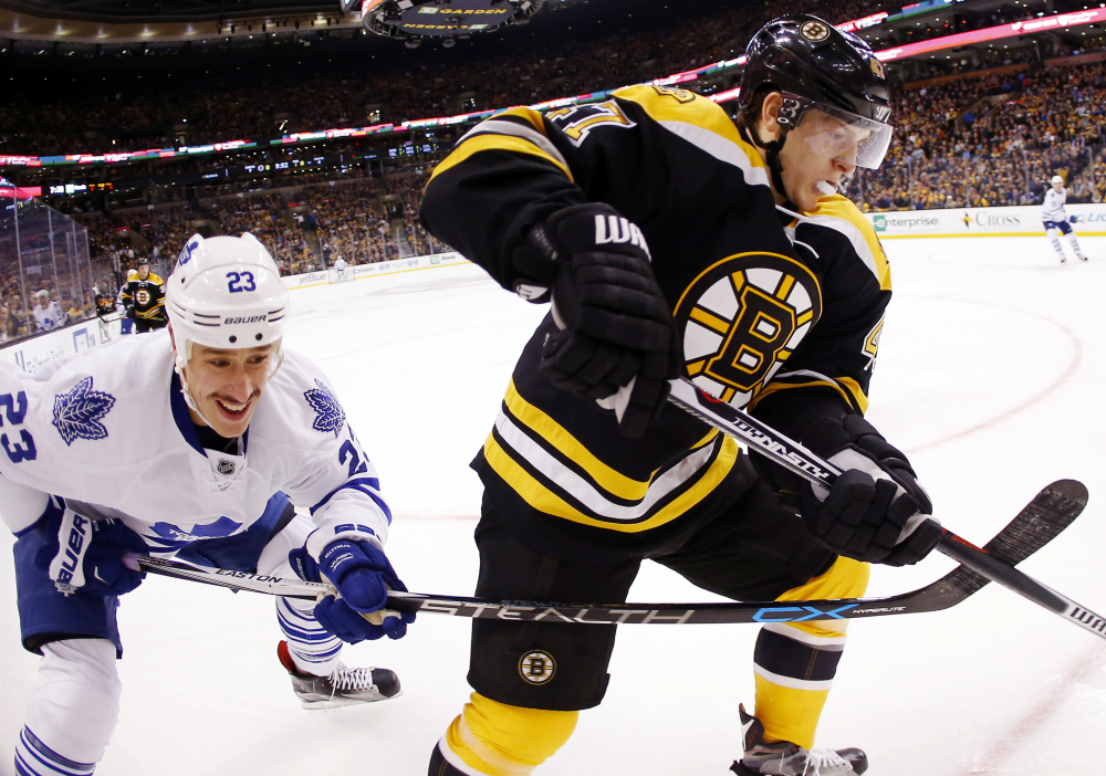 Toronto’ Shawn Matthias (23) battles Boston’s Torey Krug during the first period of a game Saturday in Boston.