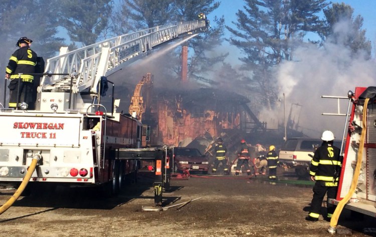 The house beling to Carolyne Surma and Ernold Lumbert at 63 Dube Lane in Solon burns as firefighters from five towns work to put it out Tuesday morning.
