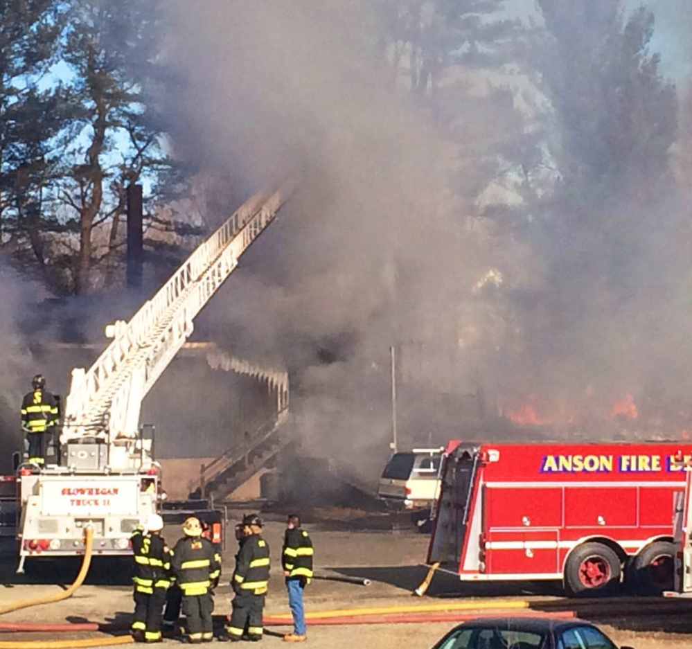 Firefighters watch as flames and smoke destroy a house and garage beloning to Ernold Lumbert and Carolyne Surma at 63 Dube Lane Tuesday morning. The damage was too extensive for the state fire marshal to investigate, but fire officials said the cause does not appear to be suspicious.