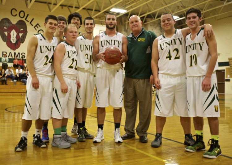 Members of the Unity College men’s basketball team stand around senior guard Peter Kopacz after Kopacz scored his 1,000th career point in a game against the University of Maine at Machias on Nov. 10.