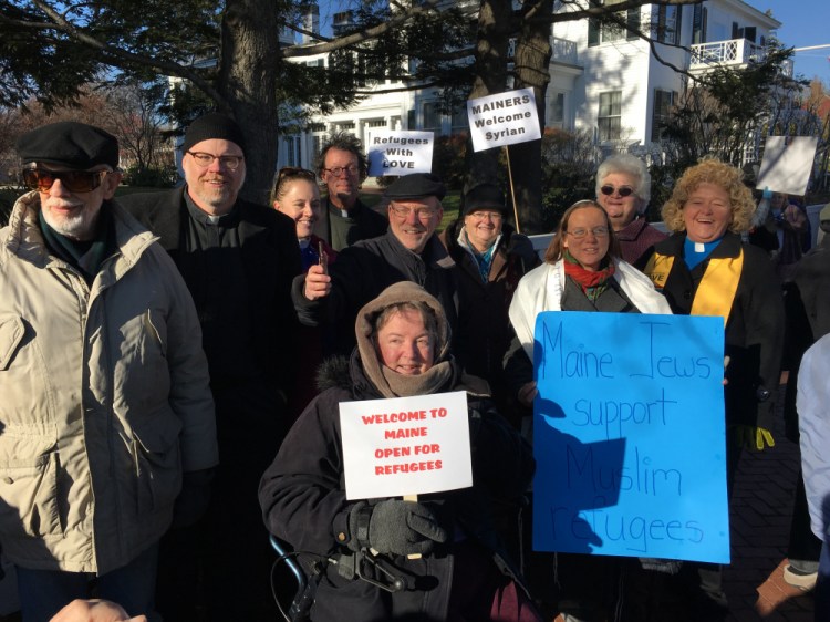 About 100 people held a vigil outside the Blaine House on Wednesday to show their support for Syrian refugees.