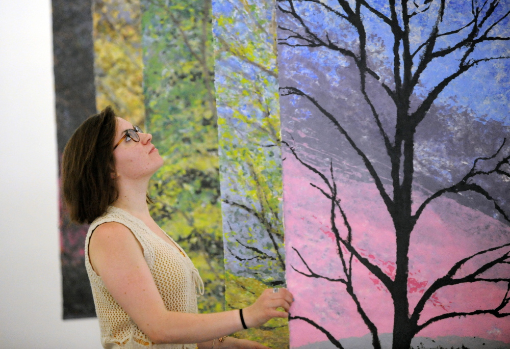 Rachel McDonald, program manager at Common Street Art Gallery, arranges paintings by local artist Christine Higgins at Common Street Art Gallery in downtown Waterville in May 2014. Waterville Creates! and Waterville Main Street are surveying area residents about what they think of the city’s cultural and arts offerings and what they’d like to see in the future.