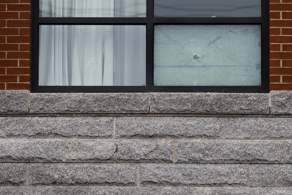 A bullet hole is seen on a second second-floor window of the Courtyard Marriott on Commercial Street on Saturday. The damage was found by two guests staying in the room Friday night.