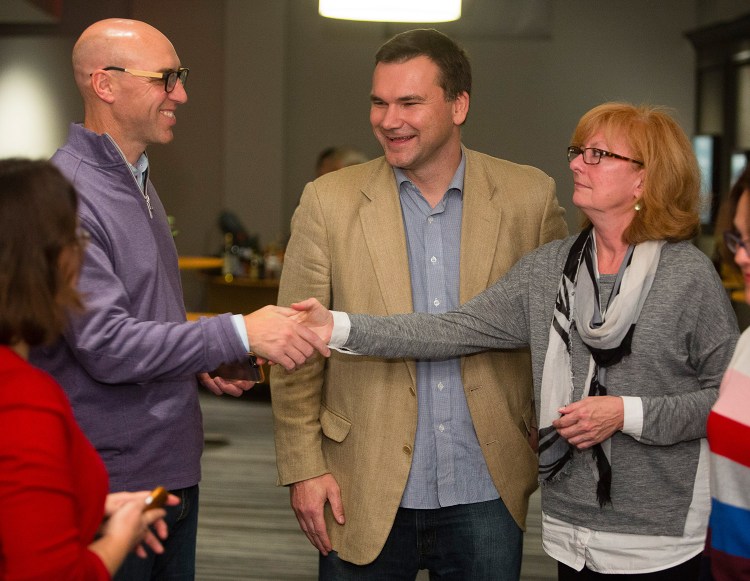 Michael Bourque, chair of the Portland Regional Chamber board, and Felicia Knight, media consultant for the campaign against a minimum wage hike in Portland, shake hands after campaign manager Toby McGrath (center) announced victory during an election night gathering at The Press Hotel.
Carl D. Walsh/Staff Photographer