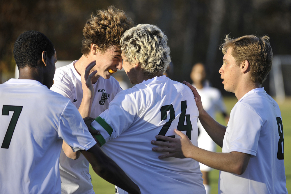 Ilyas Abdi (7), Tommy Silk (8), and Cullen Bollinger congratulate senior Aaron Lee on his goal during the second half of Waynflete’s 4-0 win over Monmouth in the Class C South boys’ soccer regional final in Portland on Wednesday. (Photo by John Ewing/Staff Photographer)