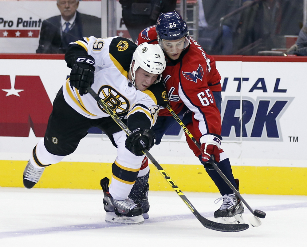 Bruins left wing Matt Beleskey (39) works for the puck against Capitals left wing Andre Burakovsky (65). (AP Photo/Alex Brandon)