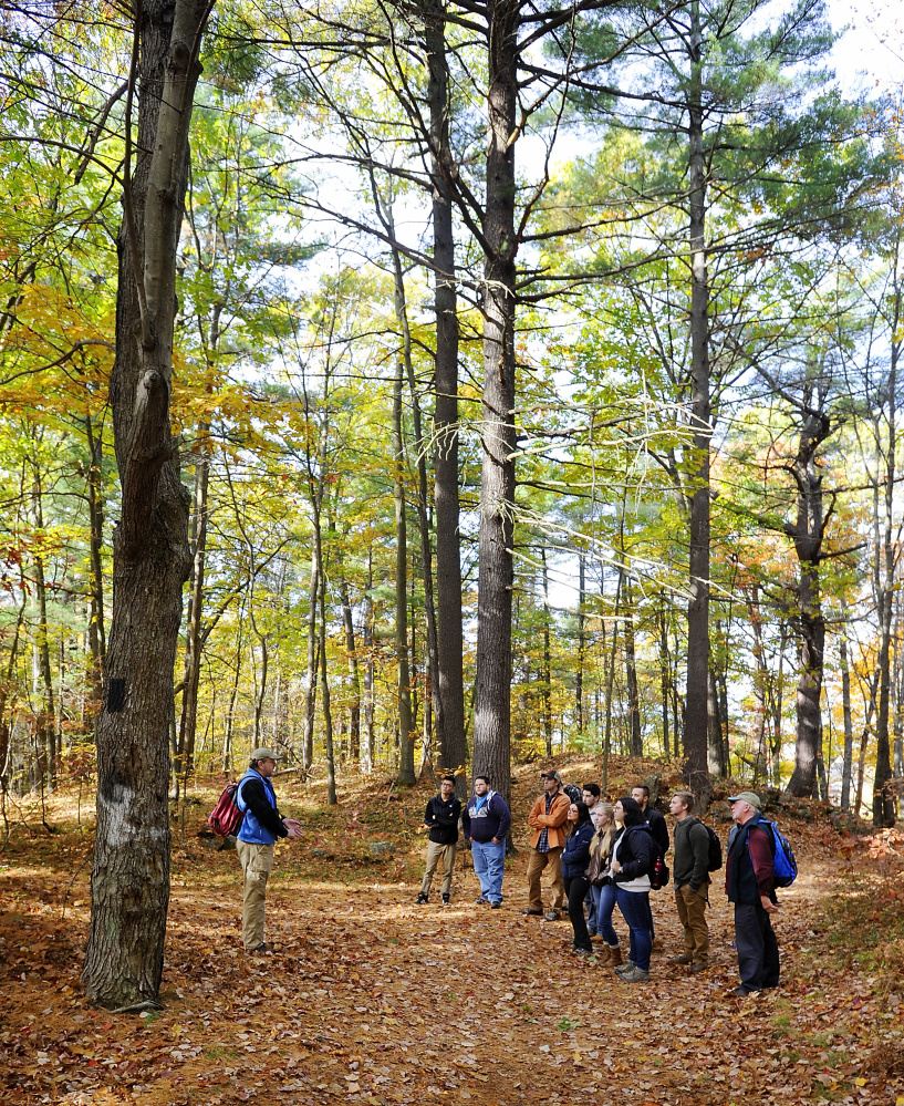 Biddeford’s Clifford Park becomes lab and classroom to UNE students and their professor, Owen Grumbling, right, as they listen to Maine Coast Heritage Trust manager Keith Fletcher, left, give the history of the 150-acre patch of pure wilderness in the belly of the city’s low-income neighborhoods.