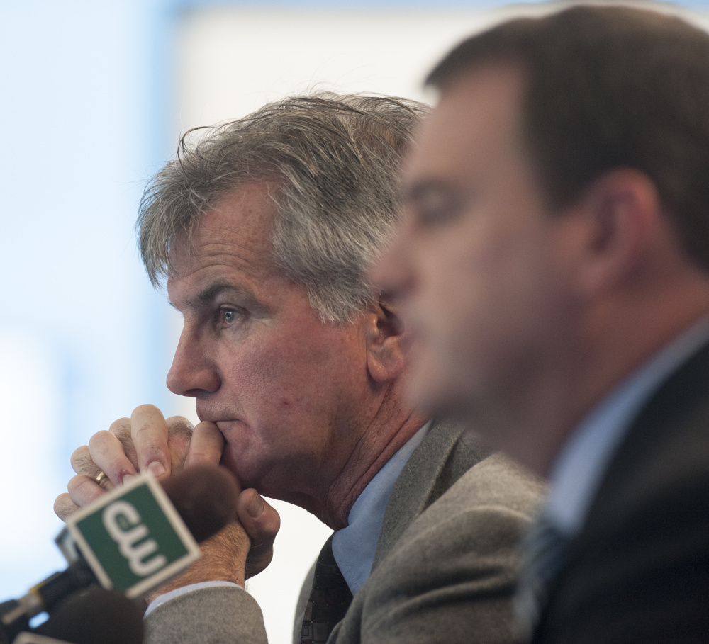 Accompanied by Athletic Director Karlton Creech, right, Jack Cosgrove, head coach of the University of Maine’s football program, announces the end of his 23-year tenure Tuesday. “I won’t miss it,” he said.