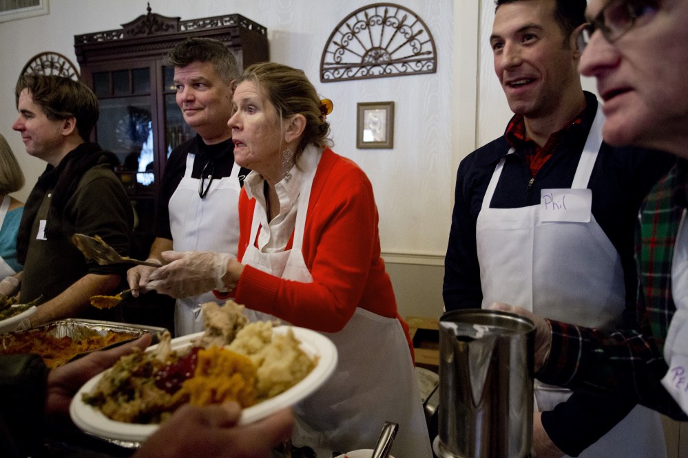 Volunteers, from left, John Monahan, Michael Quint, Marlies Heitmann, Phil Allard and Perry St. Louis serve a Thanksgiving meal at the Portland Club on Thursday during Wayside Food Programs’ annual community dinner.