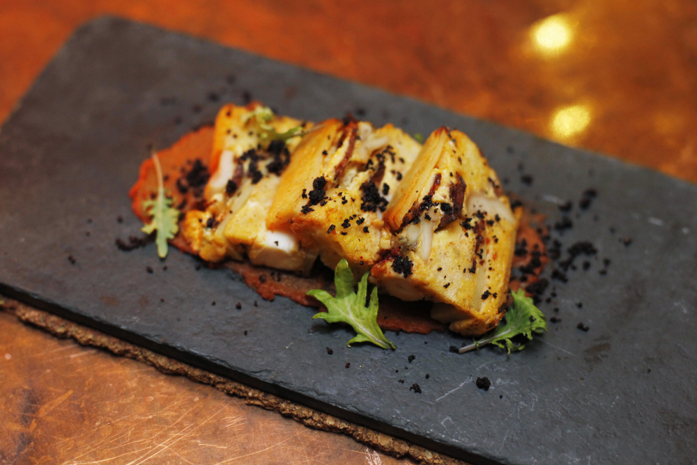 Octopus and chorizo strata with chorizo-onion puree and black olive pepper.