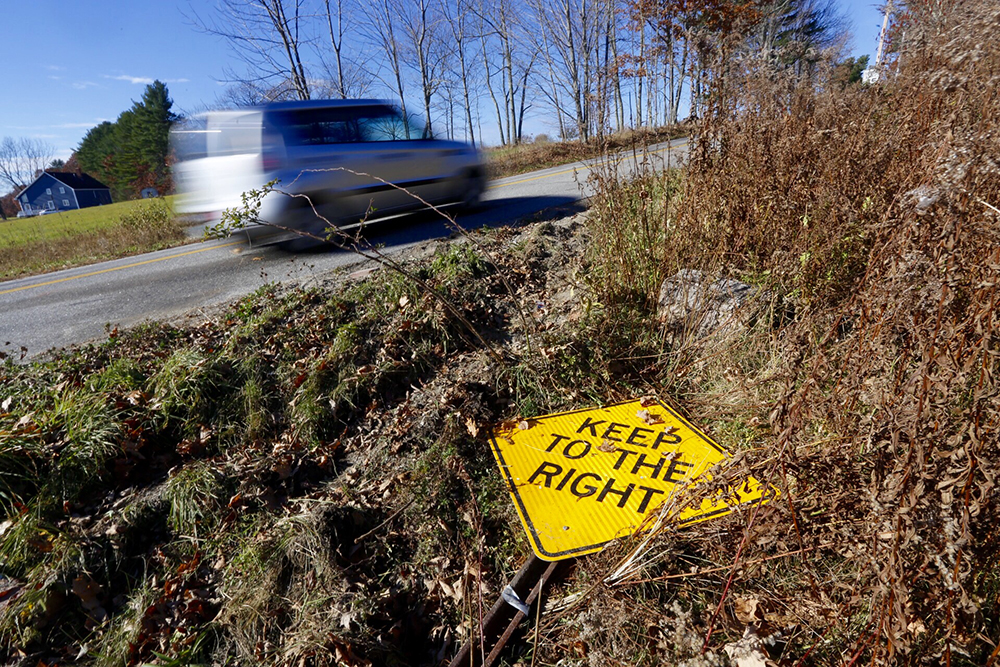 A car passes the site of a fatal, early-morning car crash on Turkey Lane in Buxton on Thursday. 
