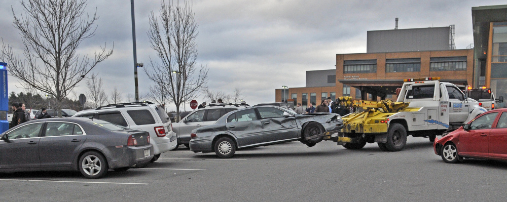 A tow truck removes the gray Buick that collided with seven parked cars on Friday in front of MaineGeneral Medical Center in Augusta.