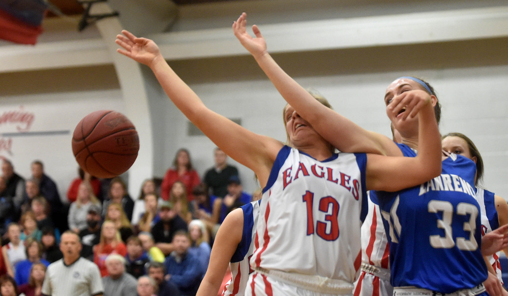 Lawrence forward Nia Irving, right, makes contact with Messalonskee’s Lydia Dexter as she goes for a loose ball during a Class A North season-opening game Friday night in Oakland.