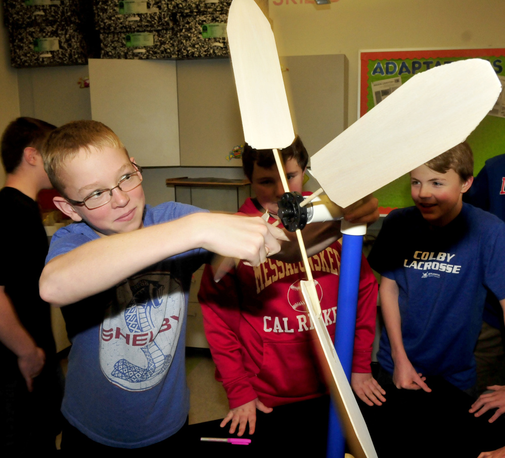 Messalonskee Middle School student Eli Ross adjusts the turbine in of a model wind turbine the class built on Thursday. Inspired by the story of a boy from Malawi, Africa, the class has begun to raise funds to help students in Wimbe, Malawi, go to school. Their goal is to raise $50,000.