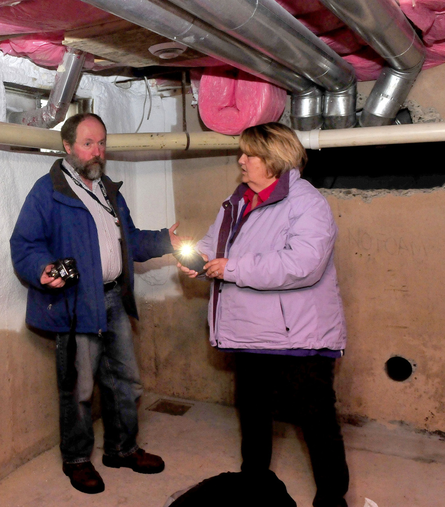 Bob Stilwell, a radon specialist with the Maine Center of Disease Control and Terry Pierson Curtis, owner of TP Environmental Consulting take photos of a radon gas ventilation system being installed in the basement of homeowner Dorothy Lavoie’s home in Benton on Monday. The system was donated by the Maine Indoor Air Quality Council as part of its Preventing Lung Cancer One House at a Time program.