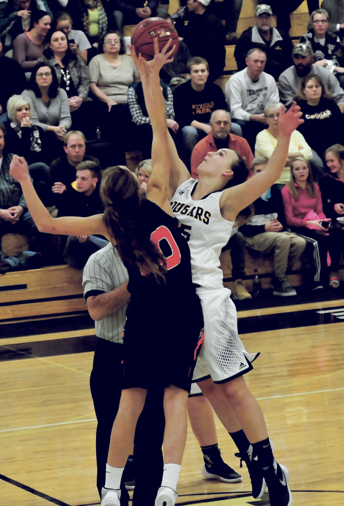 Mt. Blue’s Mackenzie Harris, right, and Gardiner’s Mary Toman go up for a tip during a Class A North game Tuesday night in Farmington.