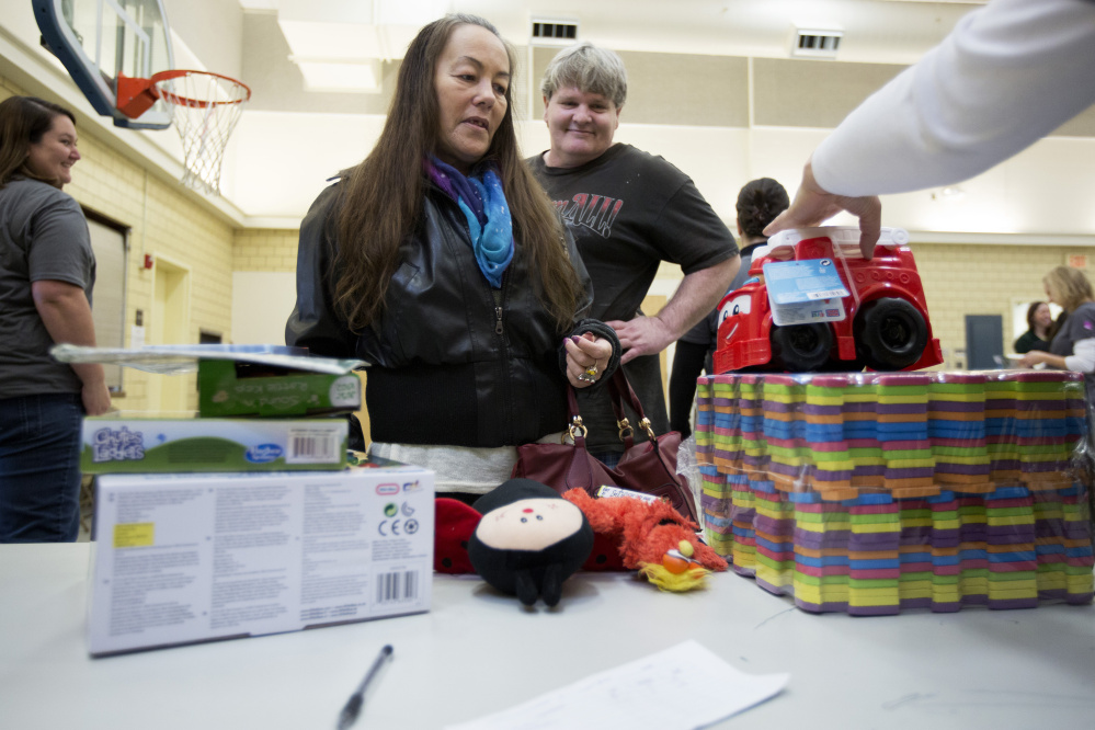 Jeannette Burns, of Portland, picks up toys Thursday for her five grandchildren at the Salvation Army’s annual toy distribution program in Portland, funded by the kettle donations.