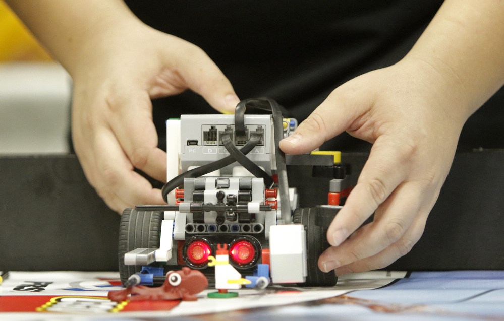 Brandon Reny, from WInslow Junior High School, adjusts to his team’s robot Saturday while competing in the Maine FIRST LEGO League State Championship at the Augusta Civic Center. Sixty teams from around the state competed in the championship.