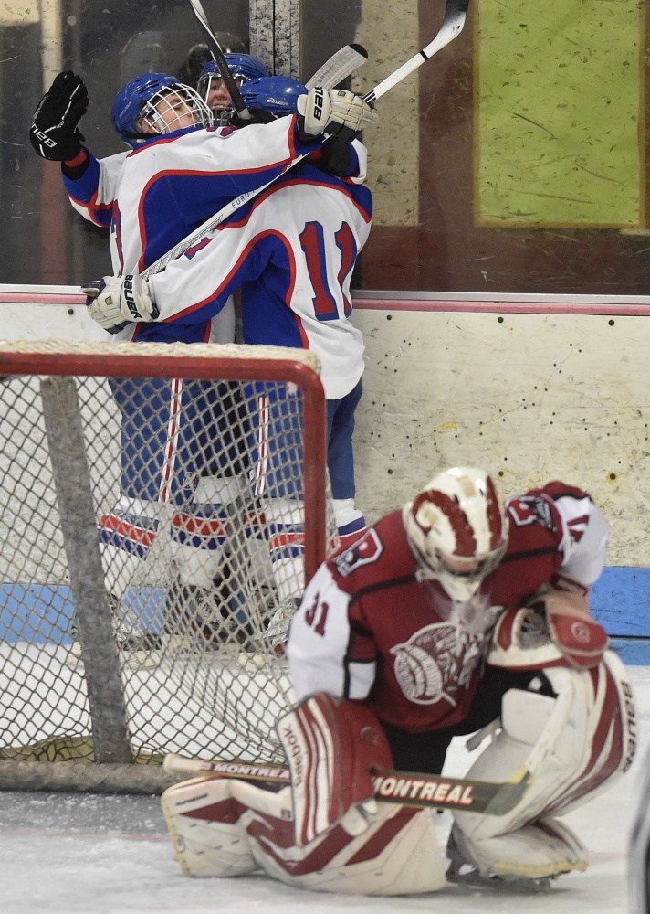 Messalonskee High School’s Jared Cunningham, center back, is swarmed by teammates Dylan Brown, left back, and Dustin Brown, back right, as Bangor High School goalie Derek Fournier (31) takes a knee in the second period Saturday at Sukee Arena in Winslow.