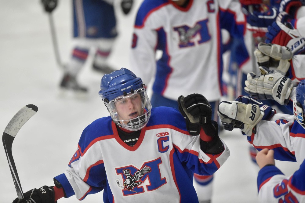 Messalonskee High School’s Jared Cunningham (19), left, celebrates his second period goal with teammates Saturday at Sukee Arena in Winslow.