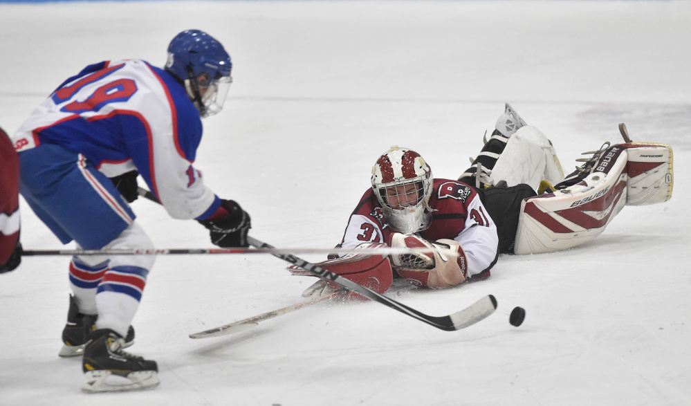 Messalonskee High School’s Jared cunningham (19) draws Bangor High School goalie Derek Fournier (31) from the goal on his way to a second period goal Saturday at Sukee Arena in Winslow.