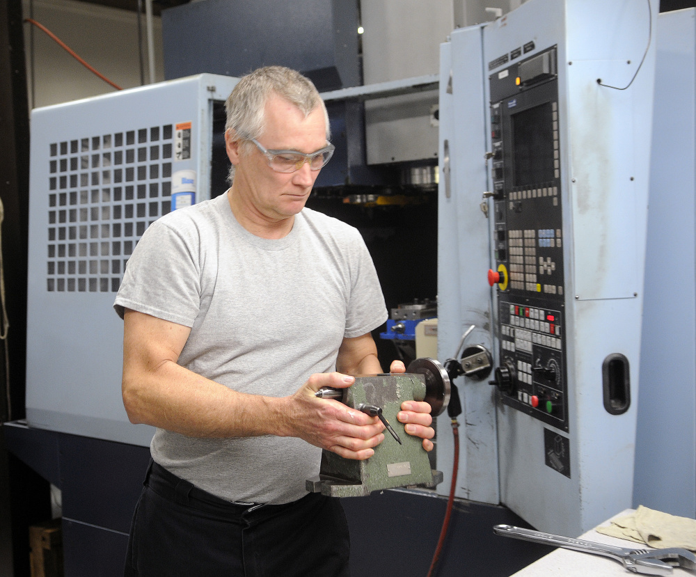 Kennebec Technologies machinist Ron Harris sets up his machine Monday at the Augusta firm for the second shift. Harris will become a partial owner of the company when it transitions to an employee stock ownership plan.