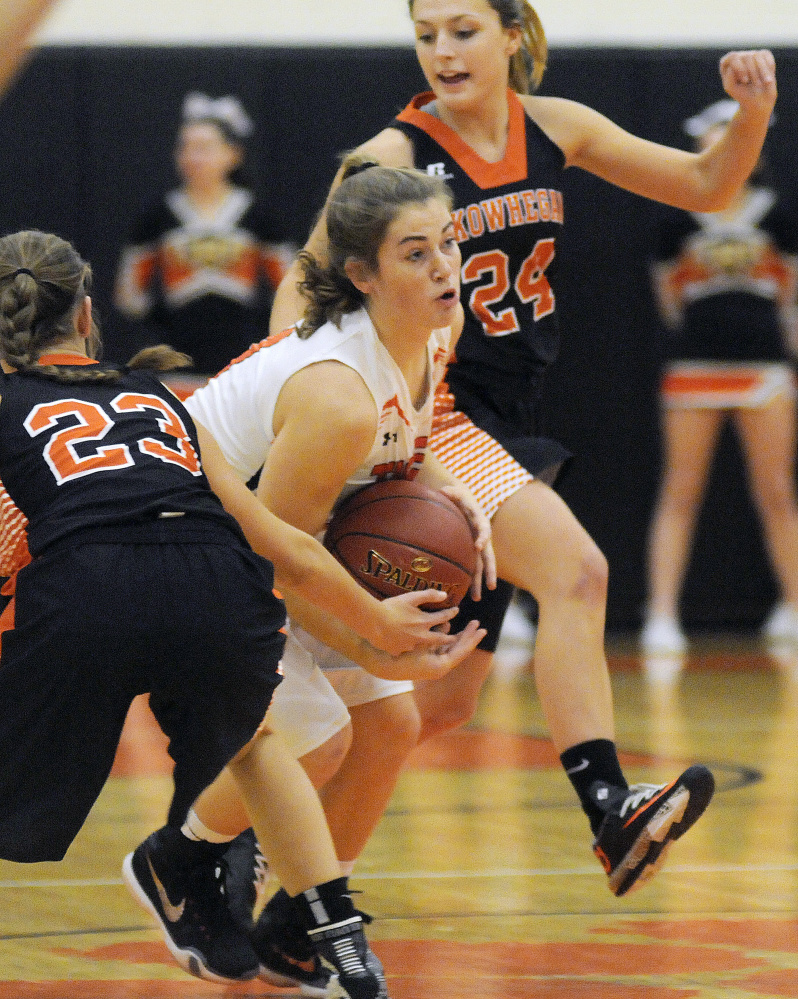 Gardiner Area High School’s Lauren Chadwick, center, dribbles through Skowhegan Area High School’s Alyssa Everett, left, and Tracey Swanson on Tuesday in Gardiner.