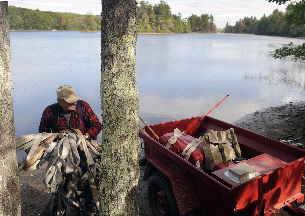 South China volunteer firefighter Bob Dow stacks a fire hose in a trailer at the landing on Branch Pond in Palermo in this September file photo.