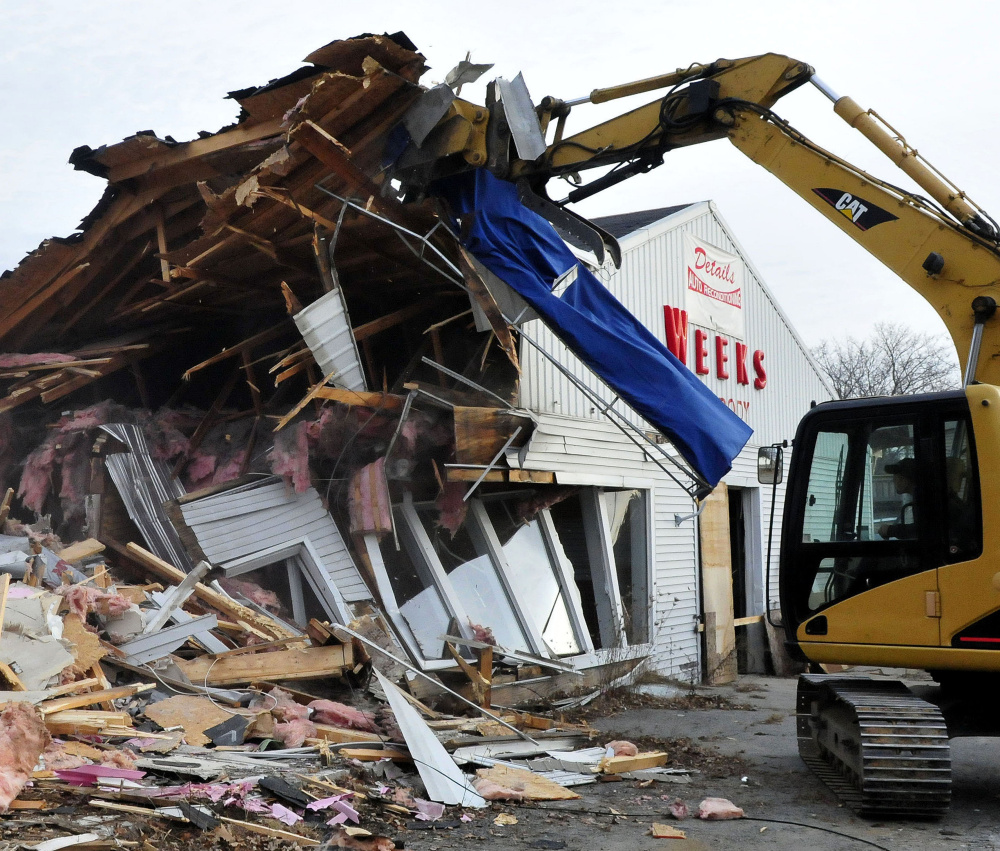 Jeremy Marcoux breaks down walls at the former Weeks Auto Body shop on Kennedy Memorial Drive in Waterville on Dec. 21.