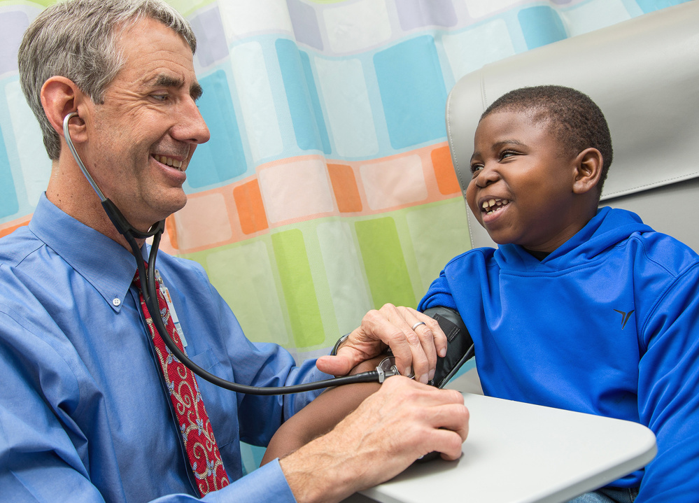 Marshall Jones, right, laughs with Dr. John Barcia in the Battle Building at the University of Virginia Children’s Hospital in Charlottesville, Va. A shake-up of the nation’s kidney transplant system is getting more organs to patients once thought nearly impossible to match, according to early tracking of the new rules.