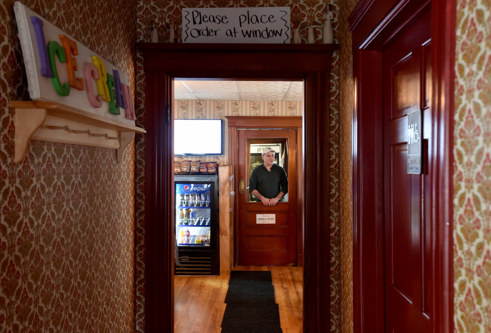 Mike Pelletier, owner of M&M’s Ice Cream Parlor and Fireside Cafe on Main Street in Madison waits to take an order on Thursday.