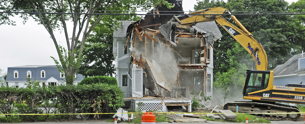 A McGee Construction excavator operator tears down 53 Chapel St. on Aug. 20 in Augusta as part of Kennebec Saving Bank’s expansion of its parking area and entrance.