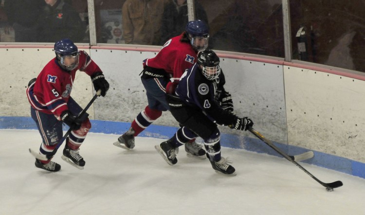 Messalonskee’s Connor Smith, left, and Shea McCann chase Waterville’s Michael Oliveira during a Class B North game Wednesday night at Sukee Arena in Winslow.