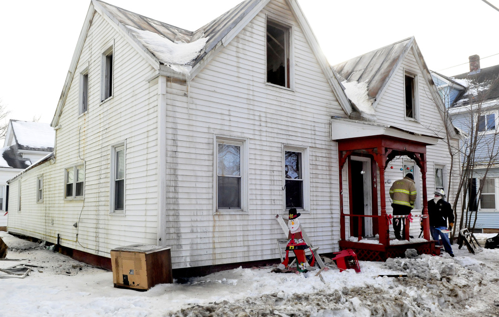 Waterville firefighter Ryan Johnston, left, confers with Ken MacMaster, an investigator with the Office of the State Fire Marshal, at 144 Water St. in Waterville, a house that was destroyed by fire Jan. 3-4. The family that was renting the home plans to move back to South Carolina.